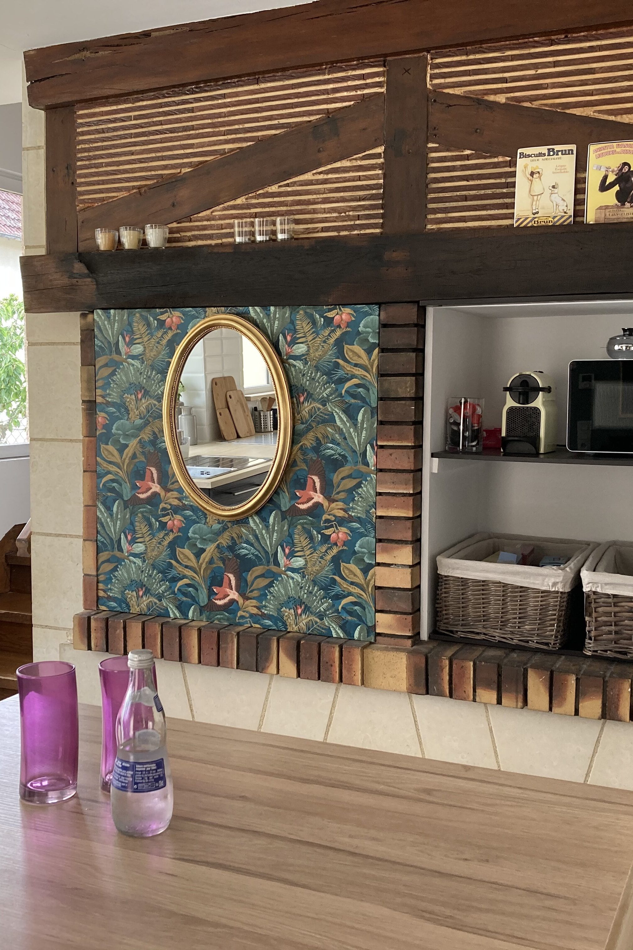 Miroir original avec papier peint fleural à Blois, coté cuisine avec micro-onde en Loir et Cher, table de cuisine en bois à Mesland, rangement en panière avec machine à café, 