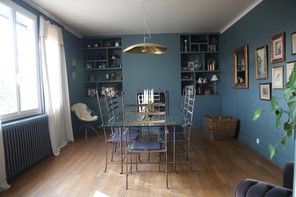 Salle à manger avec deux armoires décoratives à Blois, table basse en verre et chaise en métal en Loir et Cher, Tableau décoratif et miroir en or à Mesland, fenêtre avec rideau de couleur blanche,   