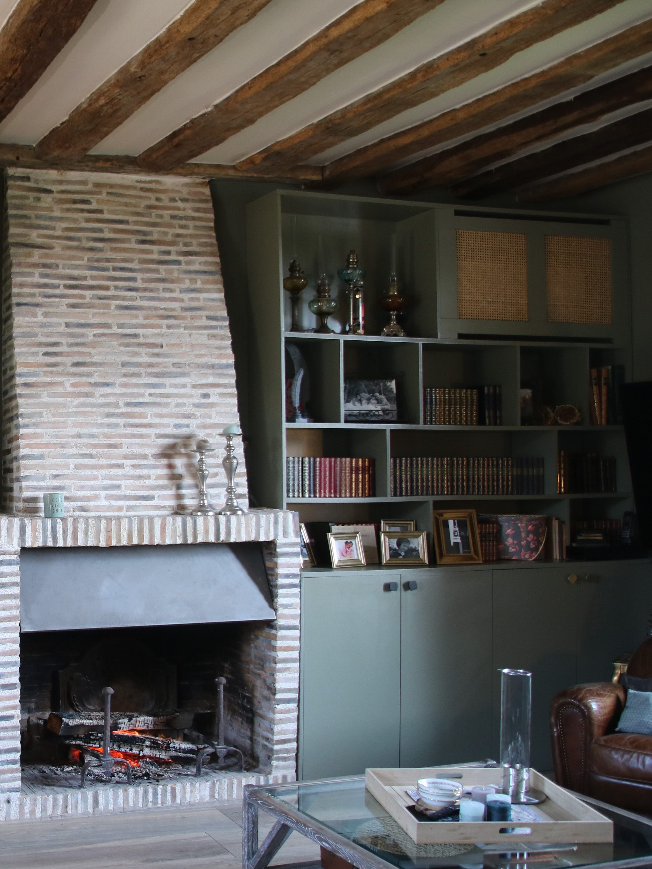 Cheminée en brique rénovée à Blois, armoire sur mesure en couleur vert foncée en Loir et Cher, Livre de décoration dans une armoire sur mesure à Mesland, table basse en verre de salon, 