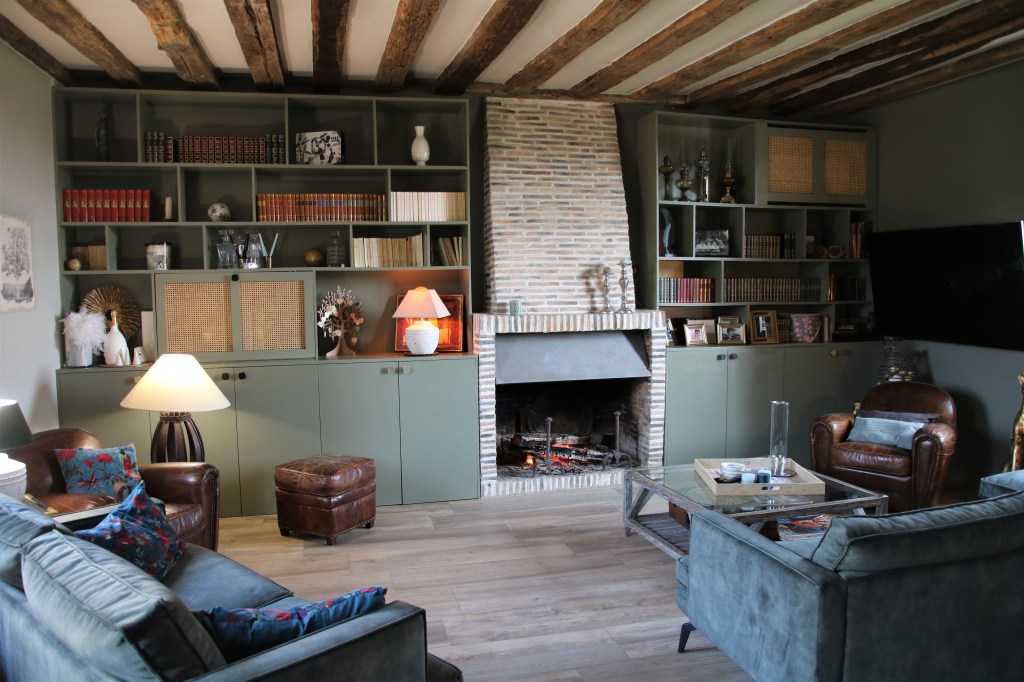 Salon avec campée et fauteuils à Blois, deux armoire pour office de bibliothèque en Loir et Cher, cheminée pour salon en brique à Mesland, poutre en bois au plafond et mur en peinture blanche, 