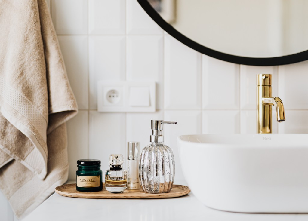 Salle de bain spacieuse à Blois, mur carrelé blanc en Loir et Cher, produit de beauté ou de bain à Mesland, robinet en or, meuble de salle de bain blanc miroir noir rond grands pour salle de bain,
